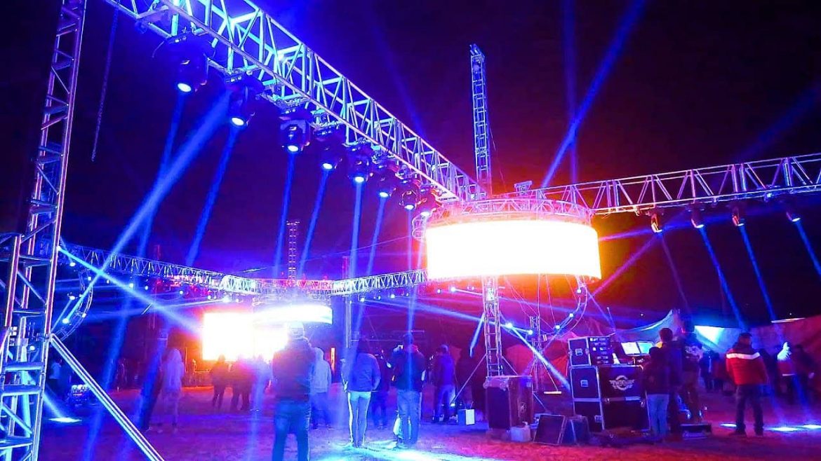 Escenario sonidero con luces azules y estructura metálica durante evento en vivo de Son Sonidero Radio