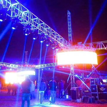 Escenario sonidero con luces azules y estructura metálica durante evento en vivo de Son Sonidero Radio